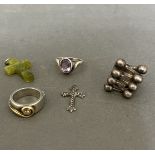 Three silver rings and a marcasite crucifix.