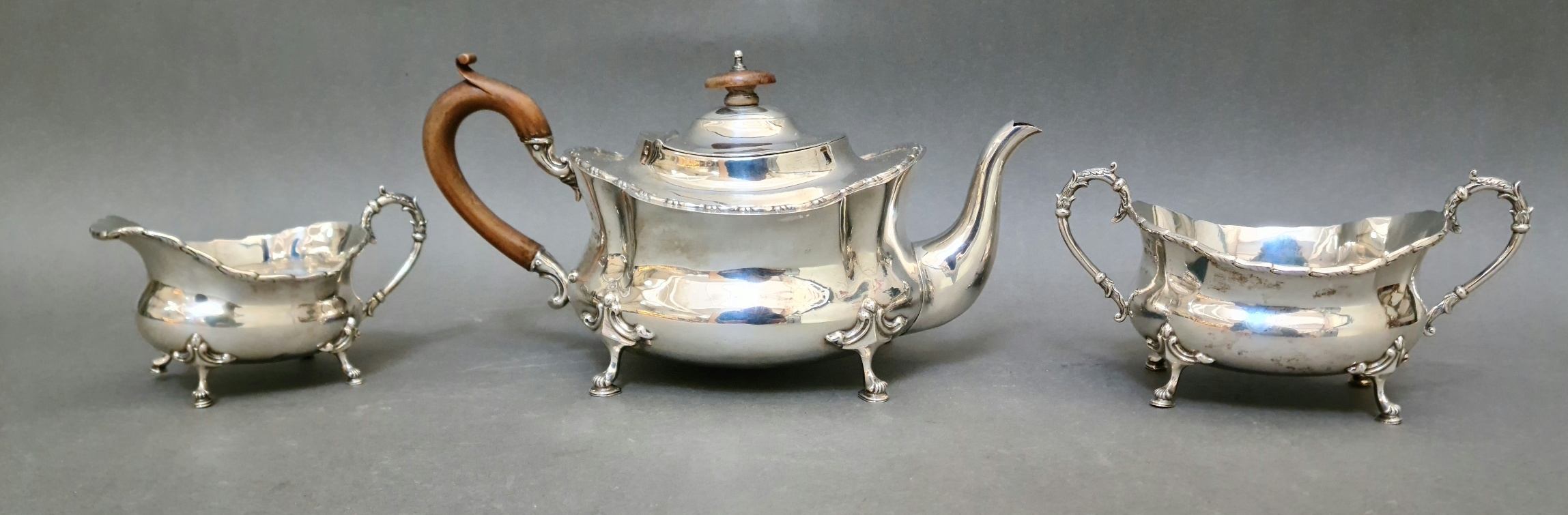 A trio of hallmarked silver tea set comprising of a "boat" teapot, a twin handled sugar bowl and a