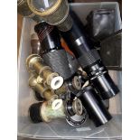 A box of assorted camera lenses and opera glasses.