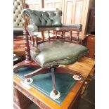 A green leather Chesterfield captain's chair.