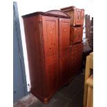 A suite of stained pine bedroom furniture comprising wardrobe, chest of drawers, a pair of bedside