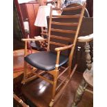 A vintage rocking chair with black vinyl seat.