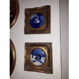 A pair of circular blue and white Delft ceramic plaques, diameter 17.5cm, gilt frames.