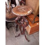 A carved mahogany plant stand.