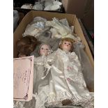 A box of porcelain dolls with COAs.