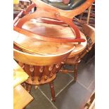 A circular pine dining table with four chairs.