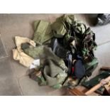 A bag of military clothing including trousers, boots, peaked cap, sweater, camouflage wear, beret,