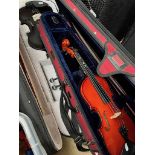 Two student violins, one black, one Stentor Student II half size, both in cases with bows together