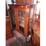 An Edwardian Art Nouveau carved mahogany display cabinet.