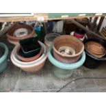 A large quantity of plant pots to include terracotta and plastic.