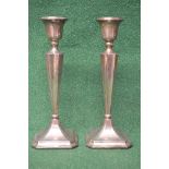 Pair of silver candlesticks having weighted bases with fluted sconces supported on inward tapering