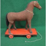 Early 20th century hessian covered wood and straw filled pull-a-long horse standing on a wooden base