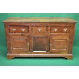 19th century oak dresser base having single central drawer flanked by single drawers with brass
