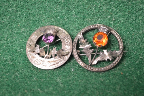 Two Sterling Silver Scottish thistle brooches one set with amethyst and the other with orange