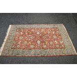 Red ground rug having blue border and decorated with figures of animals and flower heads - approx