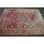 Large red and blue ground rug having red and cream borders with red, blue and green pattern - approx