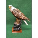 Late 20th century resin figure of an Eagle perched on a rock and standing on a square wooden