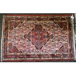 Red ground rug having white, blue and pink pattern with end tassels - approx 1.28m x 0.80m Please