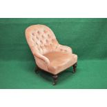 Victorian button back nursing chair having over stuffed bow fronted seat and standing on turned