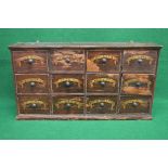 Painted pine apothecary drawers having moulded top over three rows of four drawers each having metal