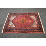 Red ground rug having blue, orange and rust pattern with end tassels - approx 1.57m x 1.11m Please