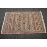 Red ground rug having blue, red, green and cream pattern with end tassels - approx 1.66m x 1.02m