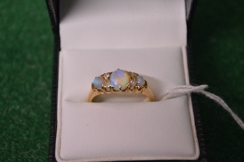 18ct yellow gold ladies ring set with central opal flanked by two small diamonds and further