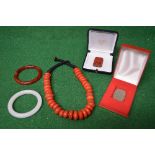 Group of Oriental jewellery to comprise: two hardstone bangles, coral (?) necklace, carved jadeite