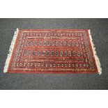 Red ground rug having white cream pattern with end tassels - approx 1.65m x 0.98m Please note