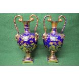 Pair of blue ground two handled vases having gilt floral decoration with enamel painted birds in