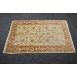 Cream ground rug having a rust pattern - approx 1.89m x 1.22m Please note descriptions are not