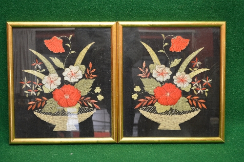 Pair of floral needleworks of flowers in baskets on a black background, in glazed gilt frames -