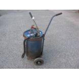 Tecalemit oil drum with hand pump, hose and nozzle on a two wheel garage trolley, marked for