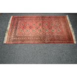 Red ground rug having white and black pattern with end tassels - 1.92m x 1.02m Please note