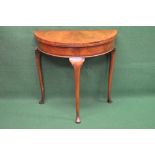 20th century walnut demi lune fold over card table the top opening to reveal baized playing surface,