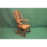 Windsor style rocking chair having pierced back splat and spindles over shaped solid seat, supported