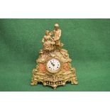 Gilt metal figural mantle clock having white painted dial with black Roman Numerals and pierced