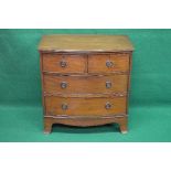 Mahogany bow fronted chest of two short and two long drawers with hoop handles, standing on swept