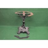 Ornate iron table base having revolving top and standing on a quad form base with scrolled bracket