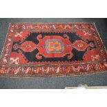 Red ground rug having orange, pink, black and blue pattern - 2.27m x 1.35m Please note