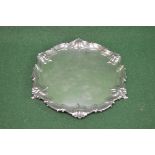 Silver salver having scalloped edge and standing on three scrolled feet, marked for London and