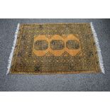 Gold ground rug having black pattern with end tassels - 1.57m x 1.04m Please note descriptions are