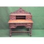 Oak carved writing desk having raised back fitted with drawers and shelf over a series of drawers,