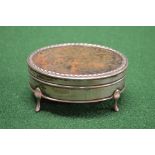 Oval silver trinket box having tortoiseshell insert lid opening to reveal lined interior, standing