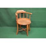 Bow back captains style chair having scrolled arms supported on bobbin turned spindles leading to