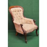 Victorian mahogany framed button back armchair having floral upholstery and standing on cabriole