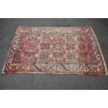 Red ground rug with blue, green and white pattern - 1.90m x 1.26m Please note descriptions are not