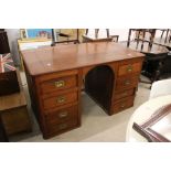 19th century Teak Desk, the slightly sloping top over a domed kneehole and an arrangement of eight