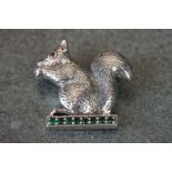 Silver squirrel brooch sat on an emerald style platform