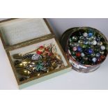 A small collection of costume jewellery together with a tin of marbles.